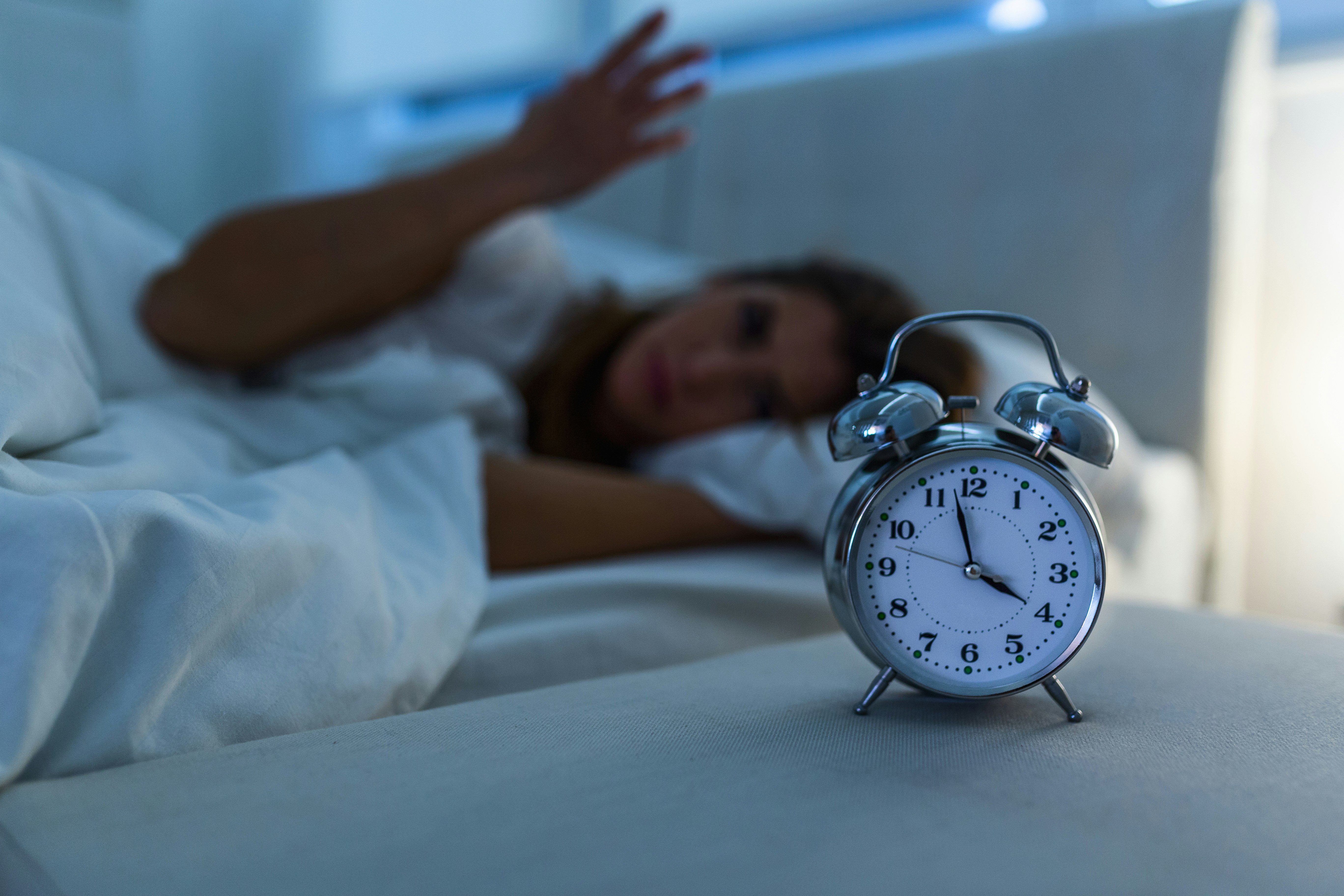 A person gets frustrated watching the clock as they cannot sleep through the night.