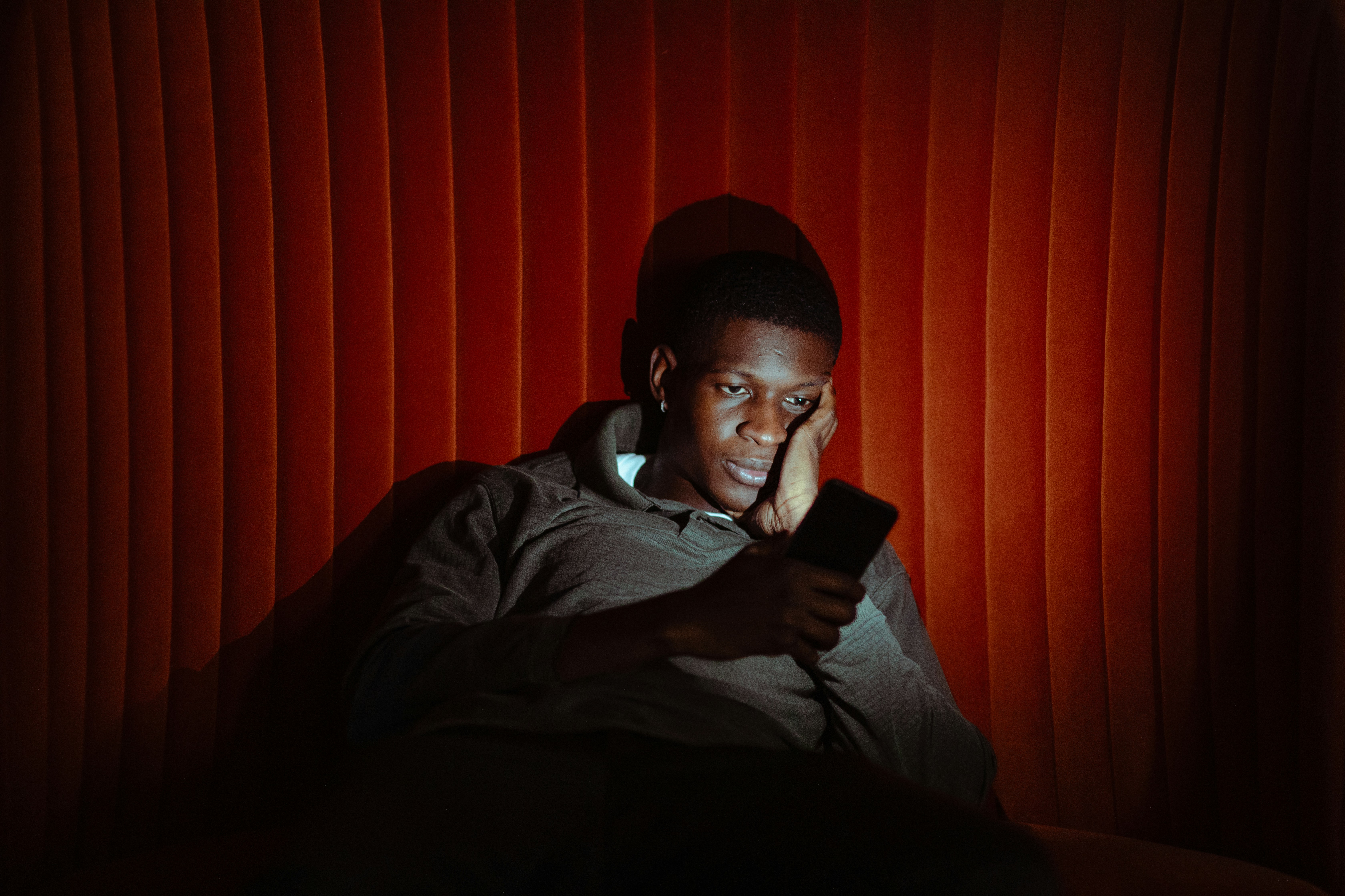 A man doomscrolls on his phone after a day filled with anxiety.